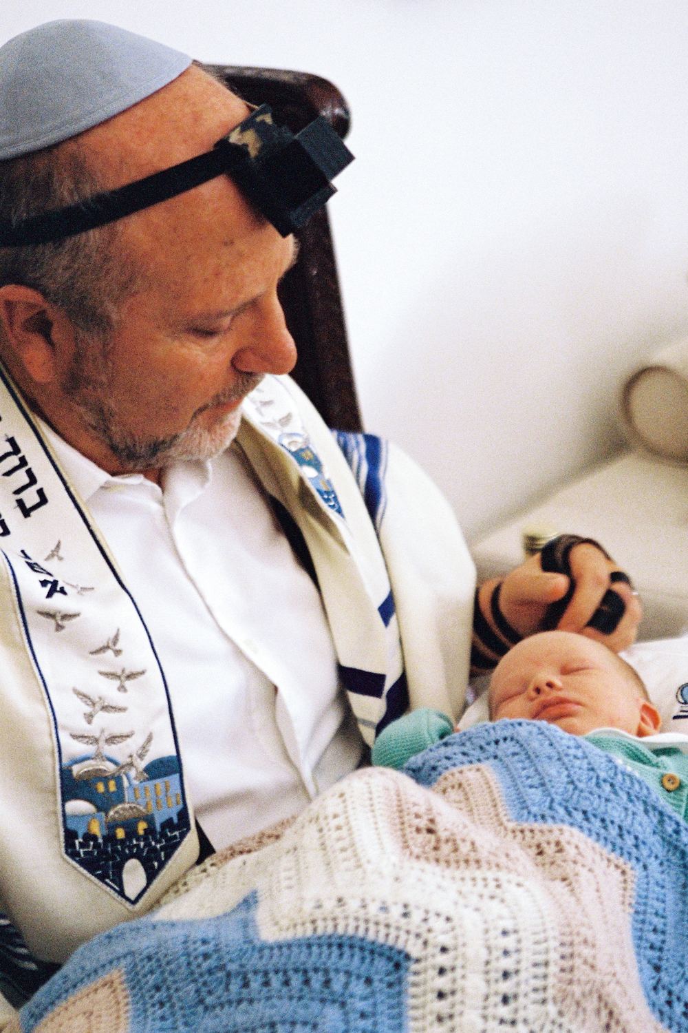 El mohel sostiene al bebé durante la ceremonia