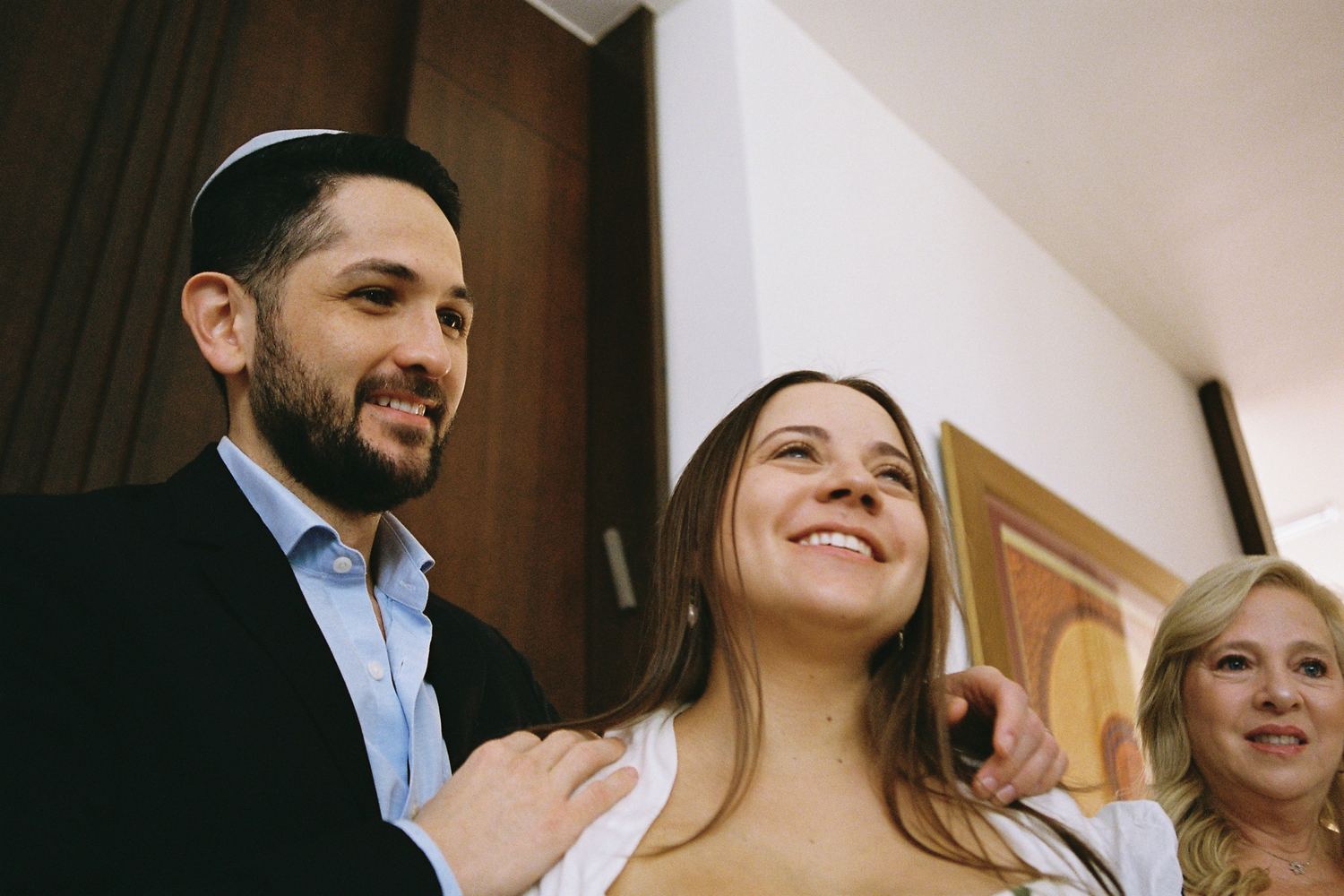 Los padres del bebé riendo entre los invitados