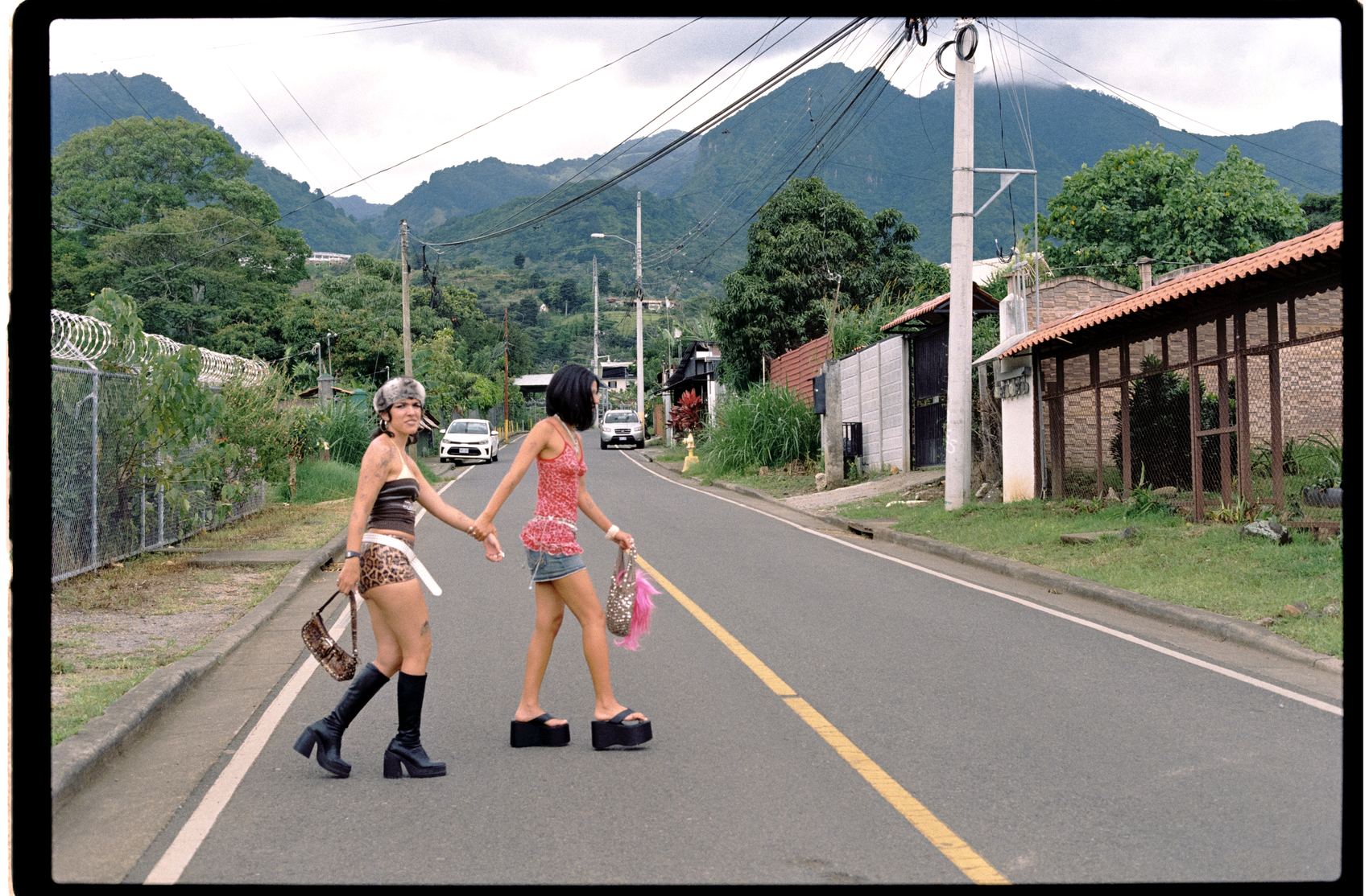 Dos mujeres cruzan de la mano una carretera de montaña