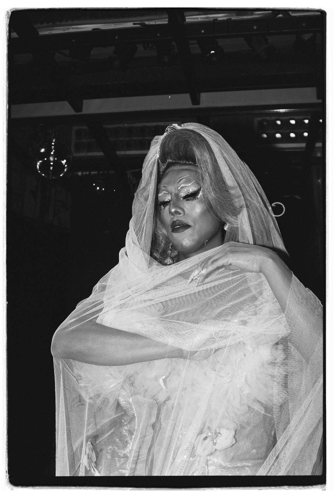 Drag queen con velo de novia sobre el escenario