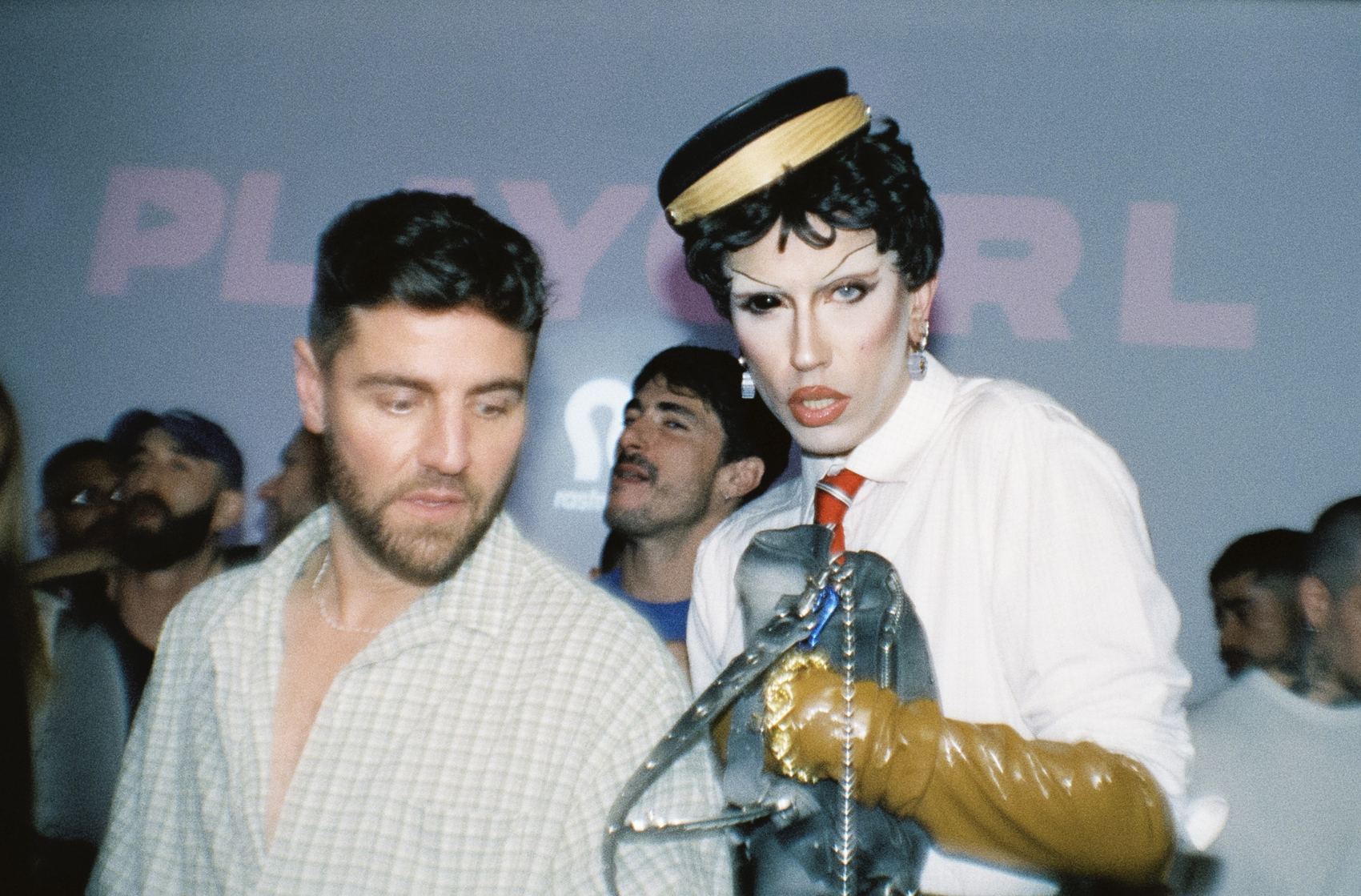 Drag queen entre dos hombres en una fiesta
