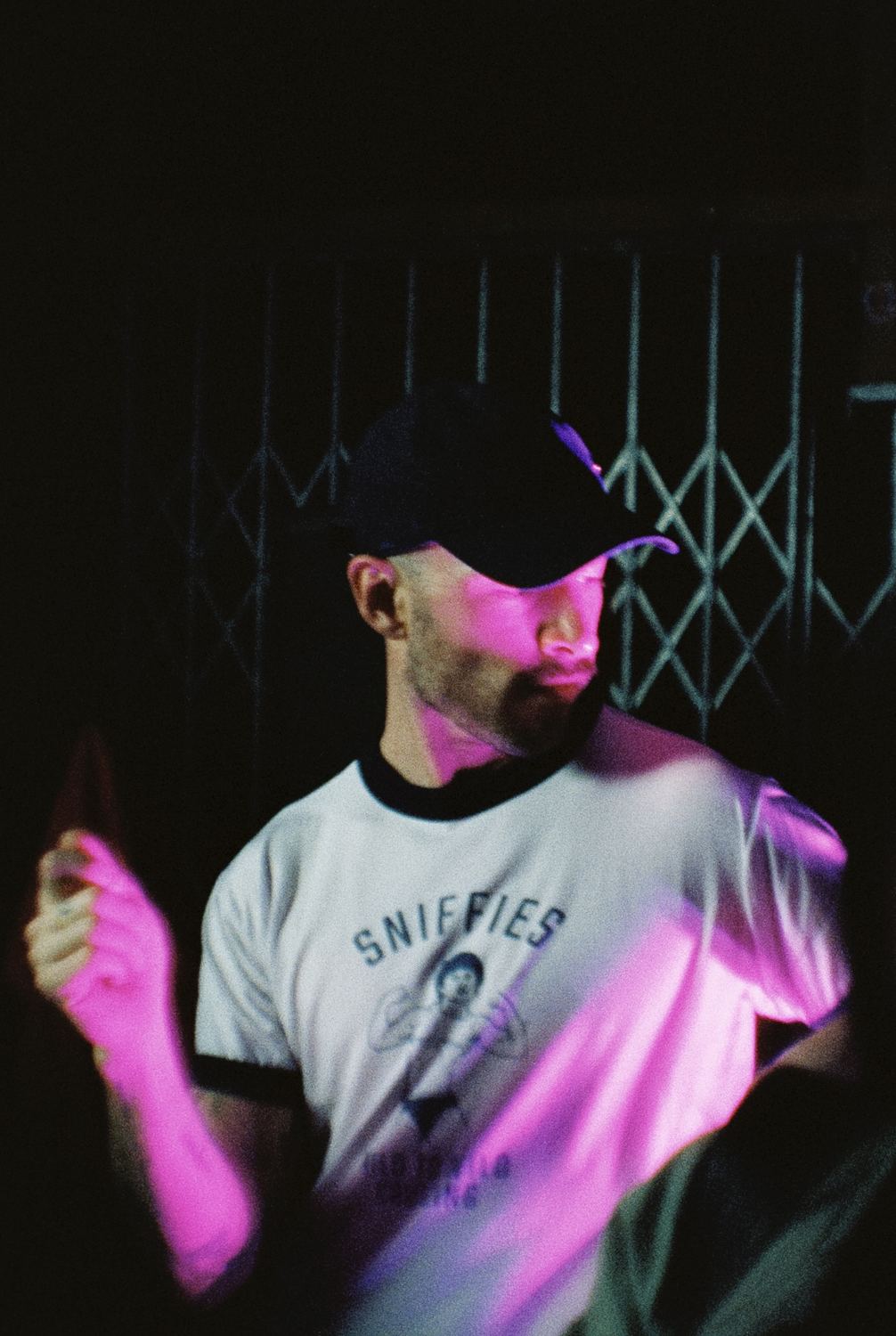 Chico con gorra bajo una luz rosa