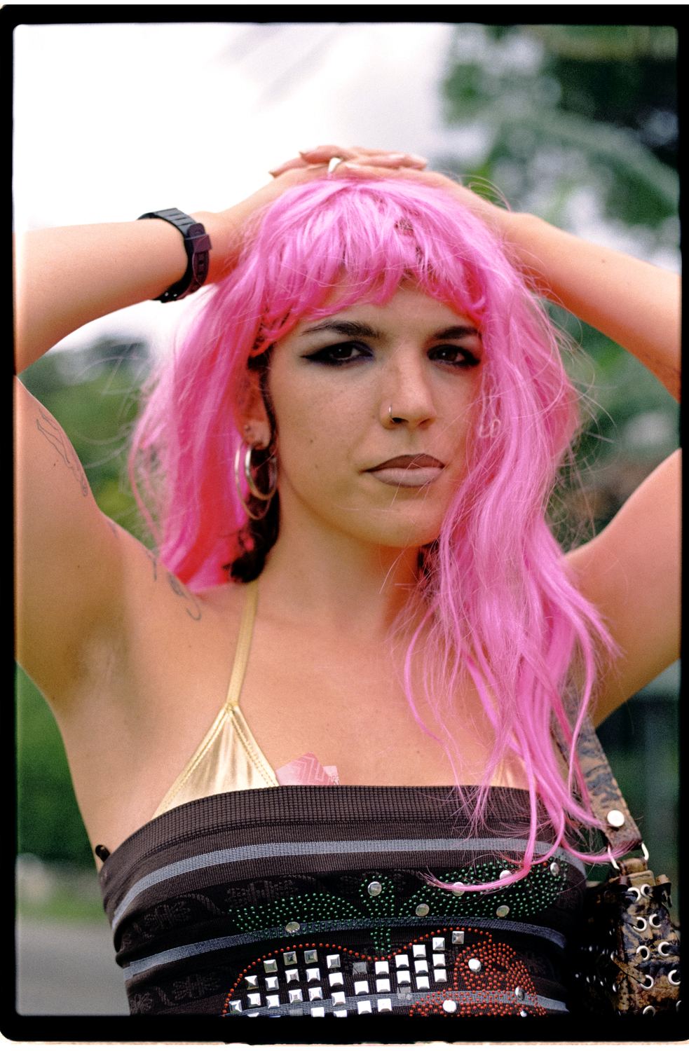 Retrato con peluca rosa y los brazos sobre la cabeza