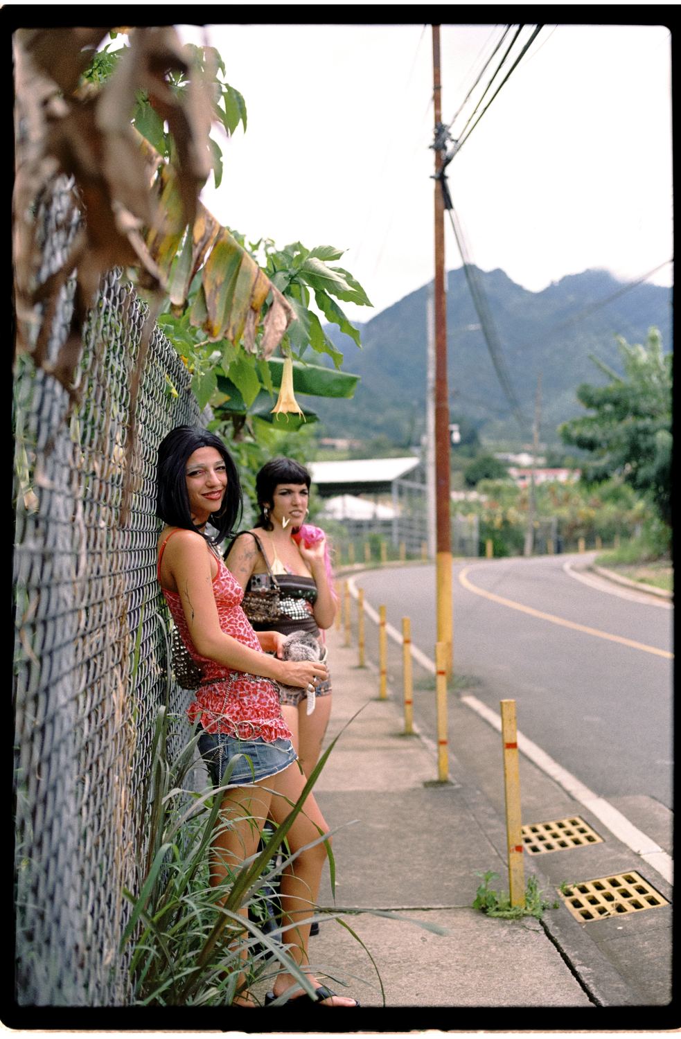 Dos mujeres junto a una valla con las montañas al fondo