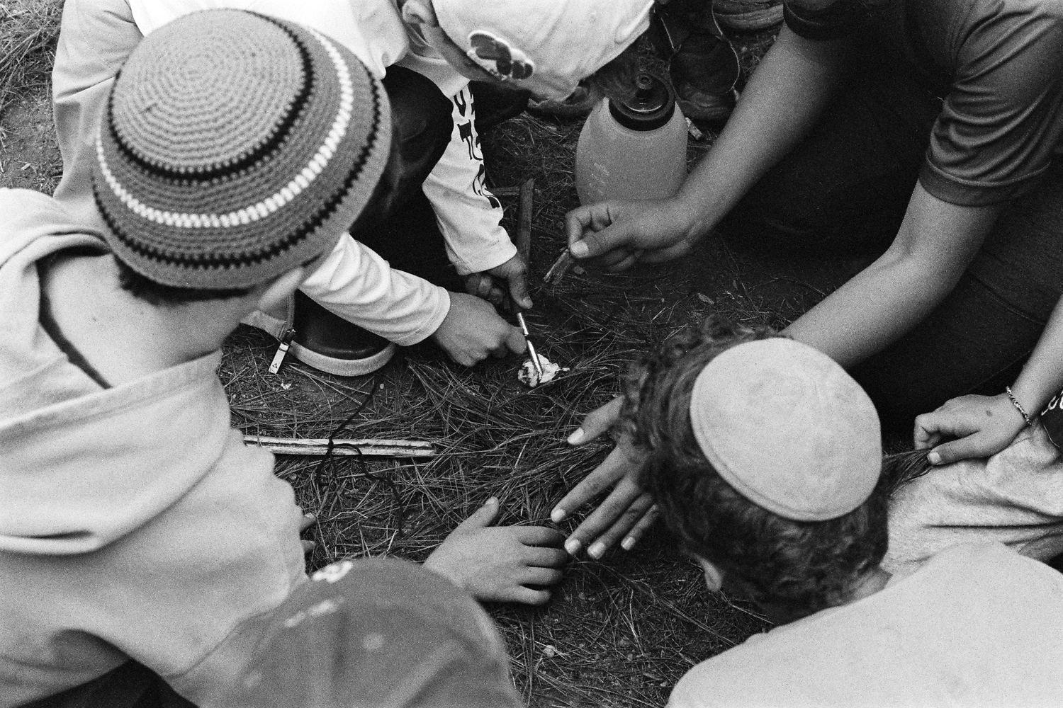 Hombres colocando los tefilín al aire libre